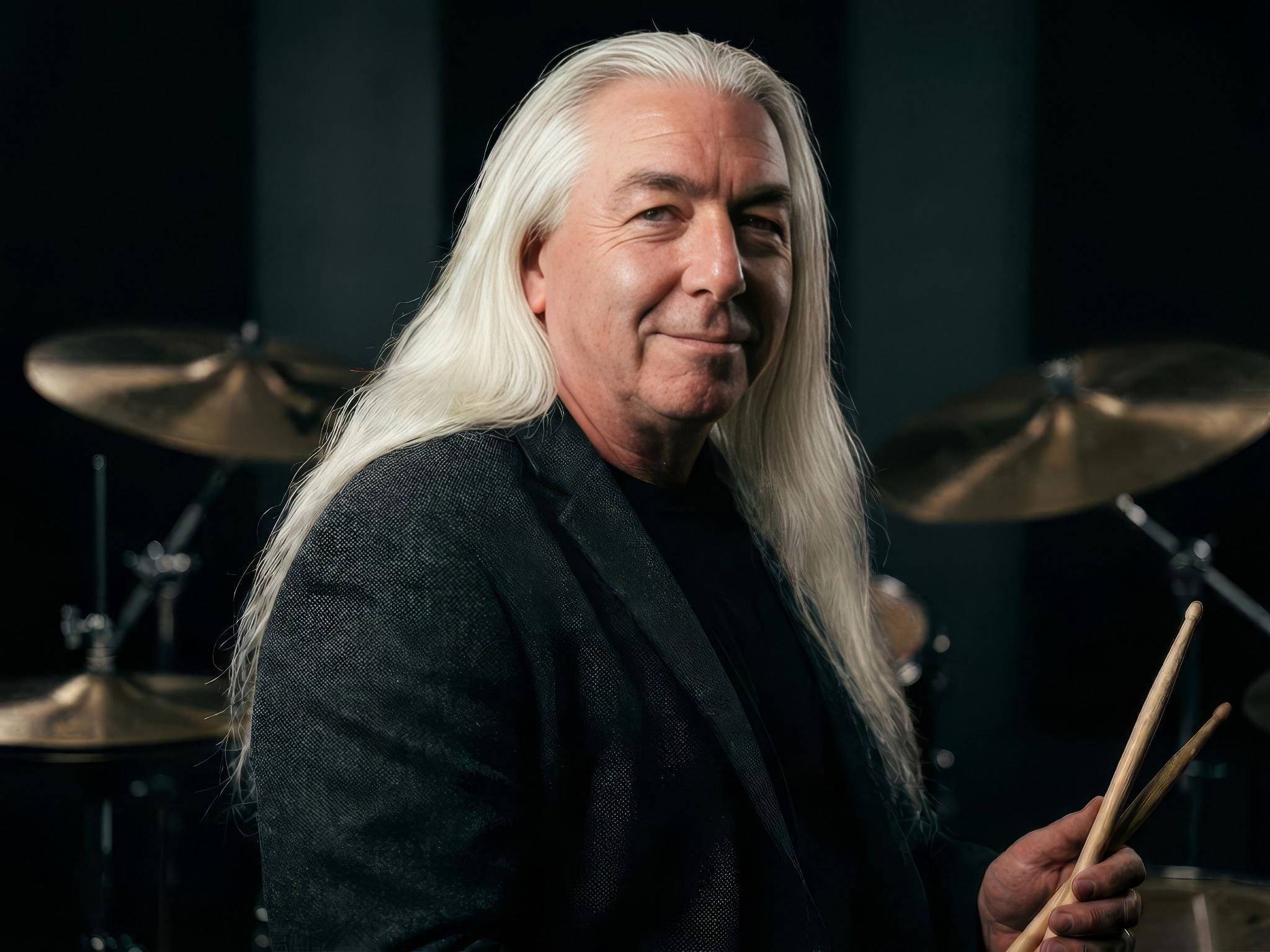 Tommy Civitillo seated at a drum kit holding drumsticks